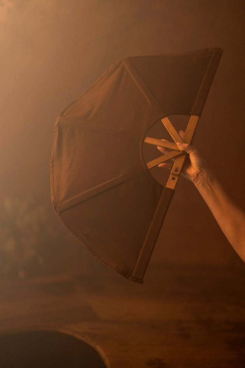 Practitioner moving air with a fan inside a steam-filled thermal room