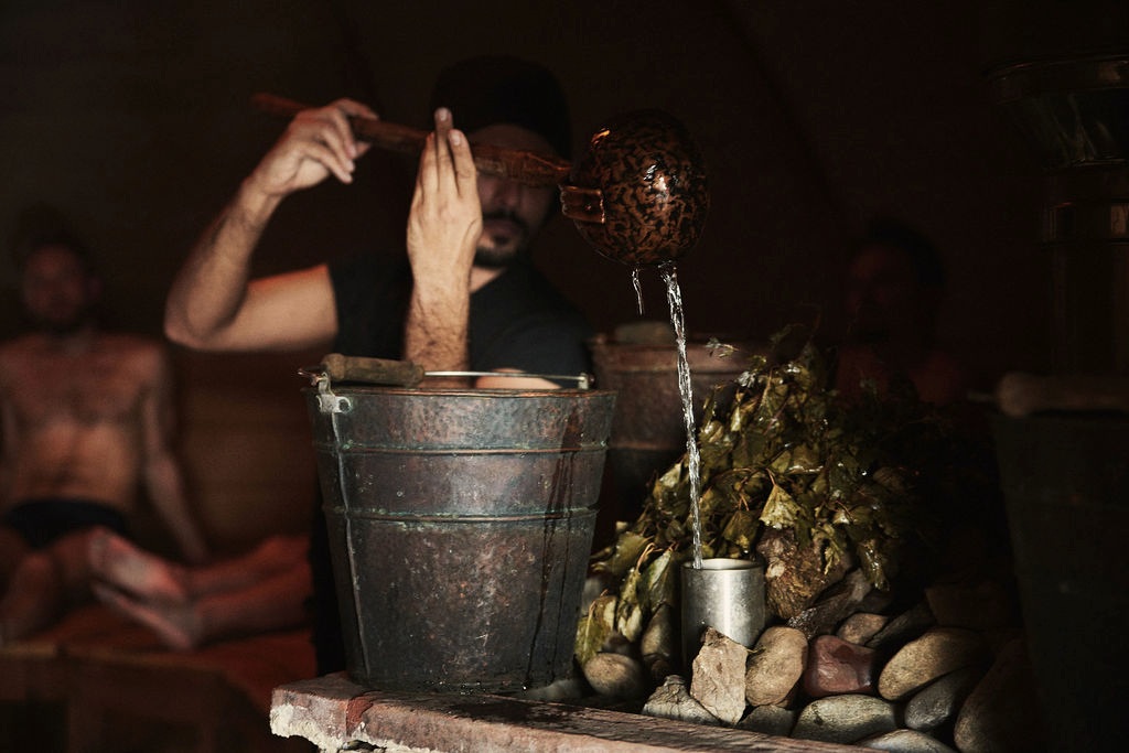 Water poured from a ladle over stones during a thermal session